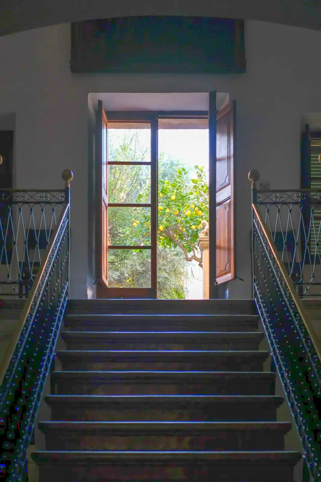 Escalera de piedra y puerta abierta al patio con limonero